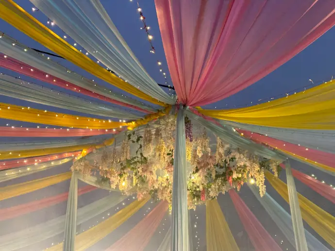 a canopy covered in colorful fabric and flowers
